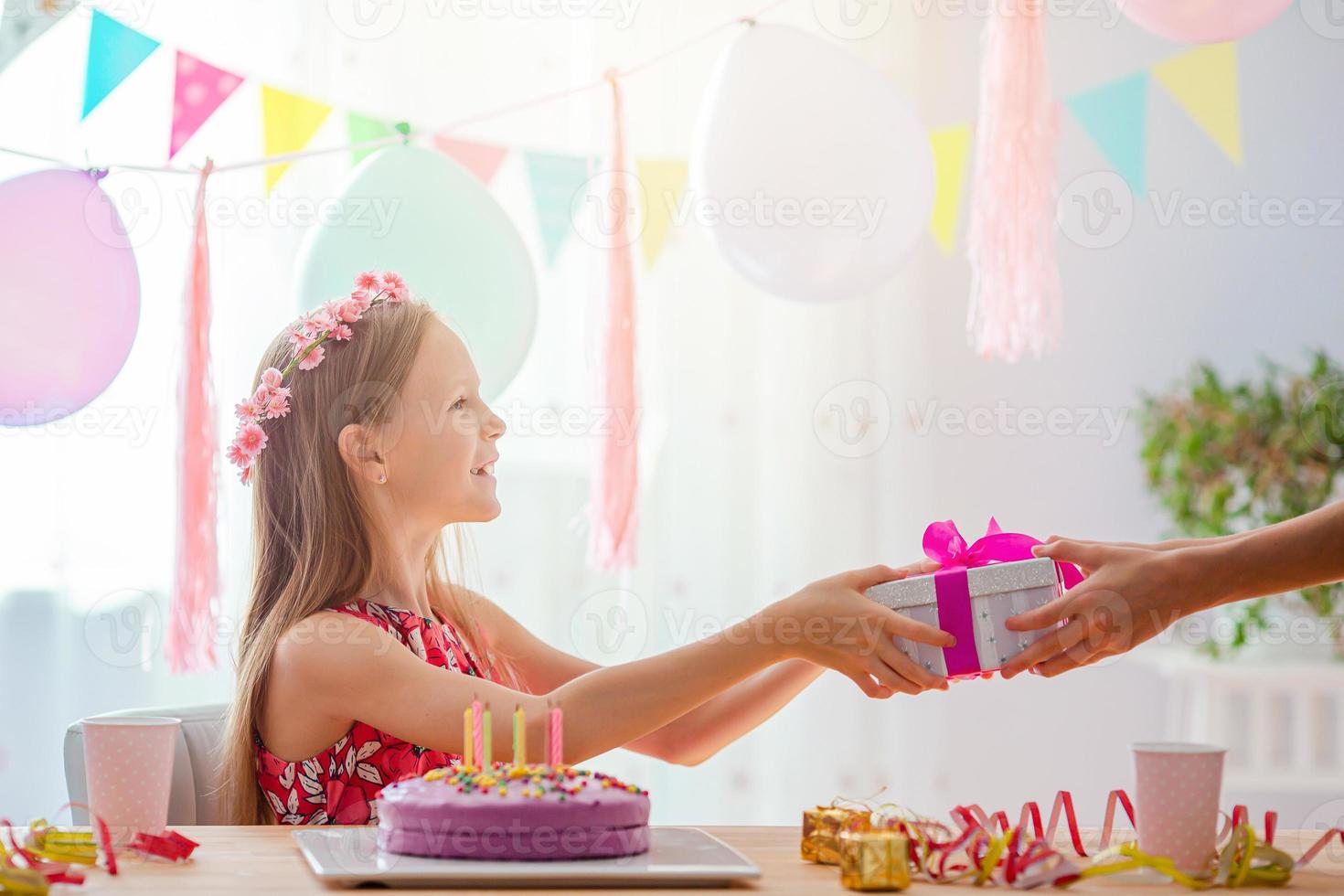 Caucasian girl is dreamily smiling. Festive colorful background with balloons. Birthday party and wishes concept. photo