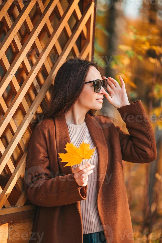 Beautiful woman in autumn park under fall foliage photo