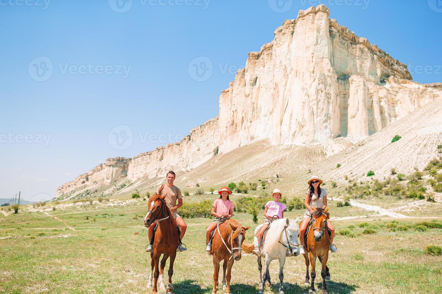 Happy family of four walking in the mountains on the sunset photo