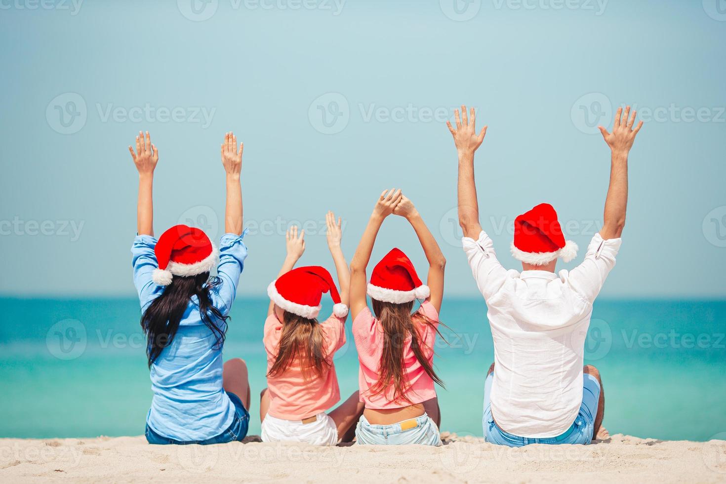 Happy family with two kids in Santa Hat on summer vacation photo