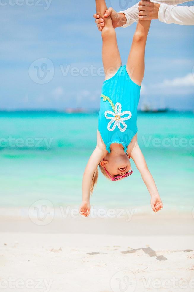 Little girl and happy dad having fun during beach vacation photo