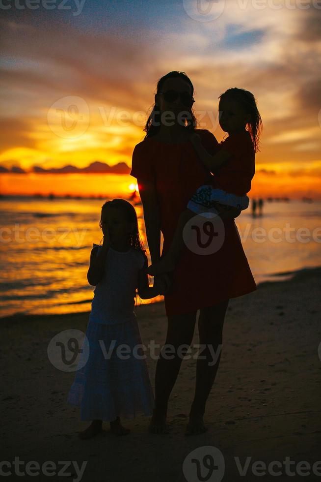 hermosa madre e hija en la playa disfrutan de la vista del atardecer foto