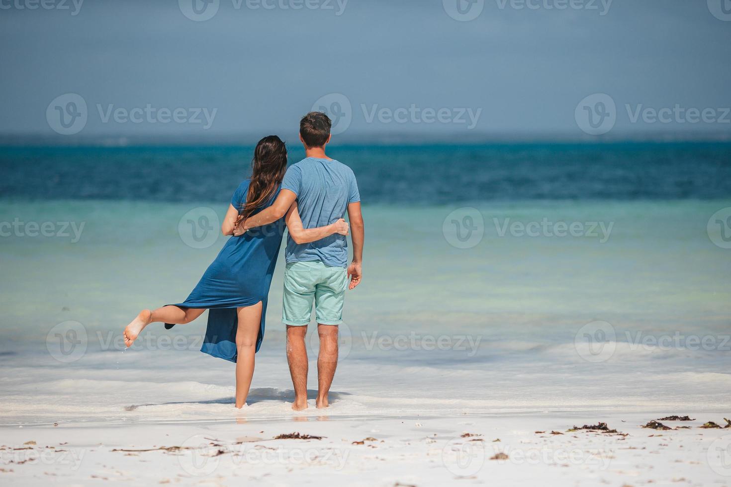Young couple on white beach during summer vacation. photo