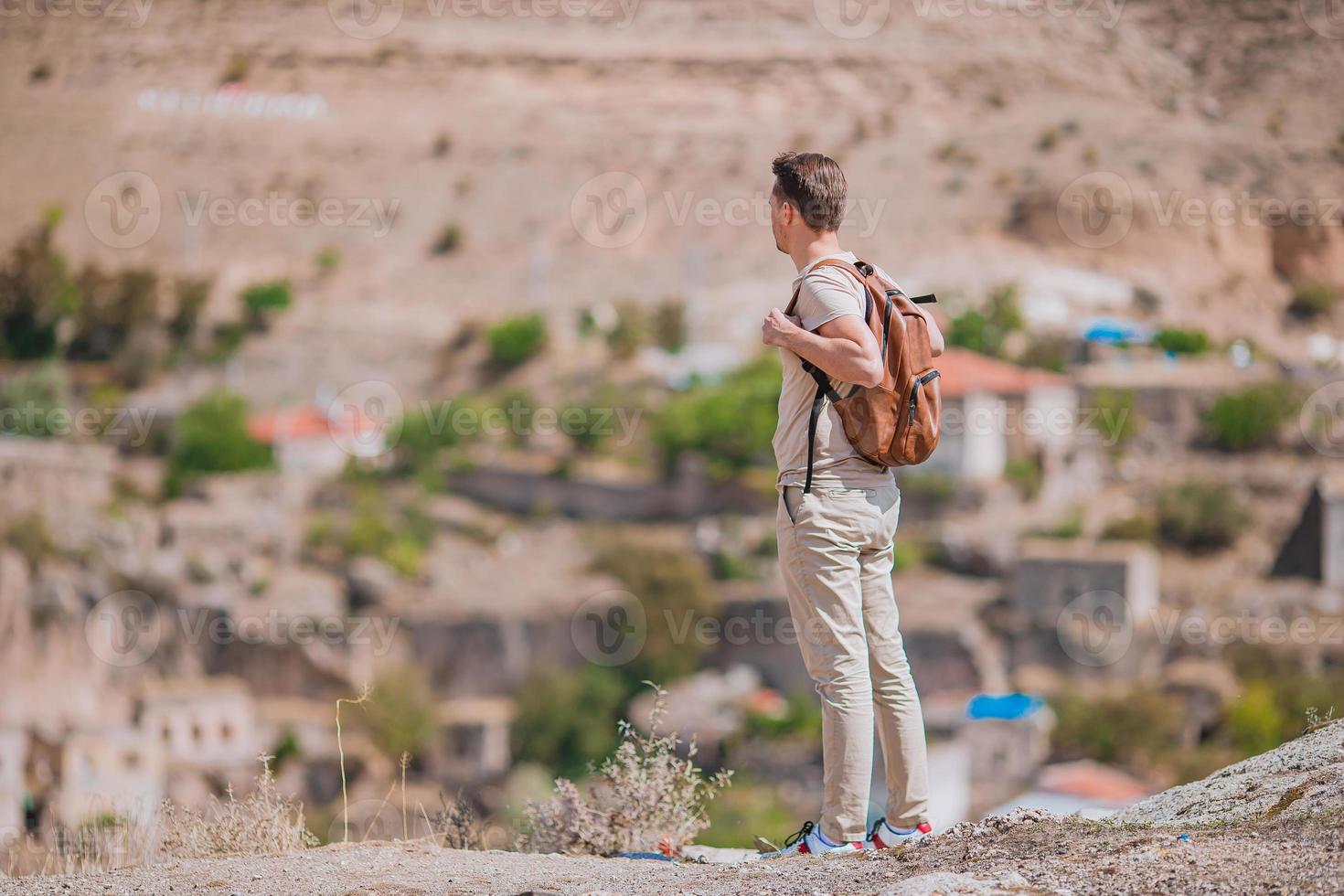 Happy young man watching hot air balloons in Cappadocia, Turkey photo