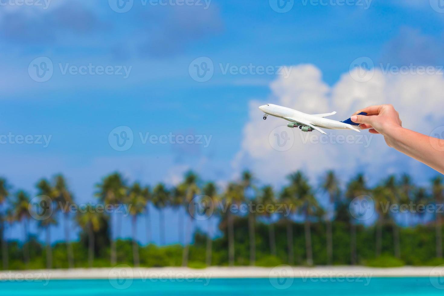 Small white miniature of an airplane on background of turquoise sea photo