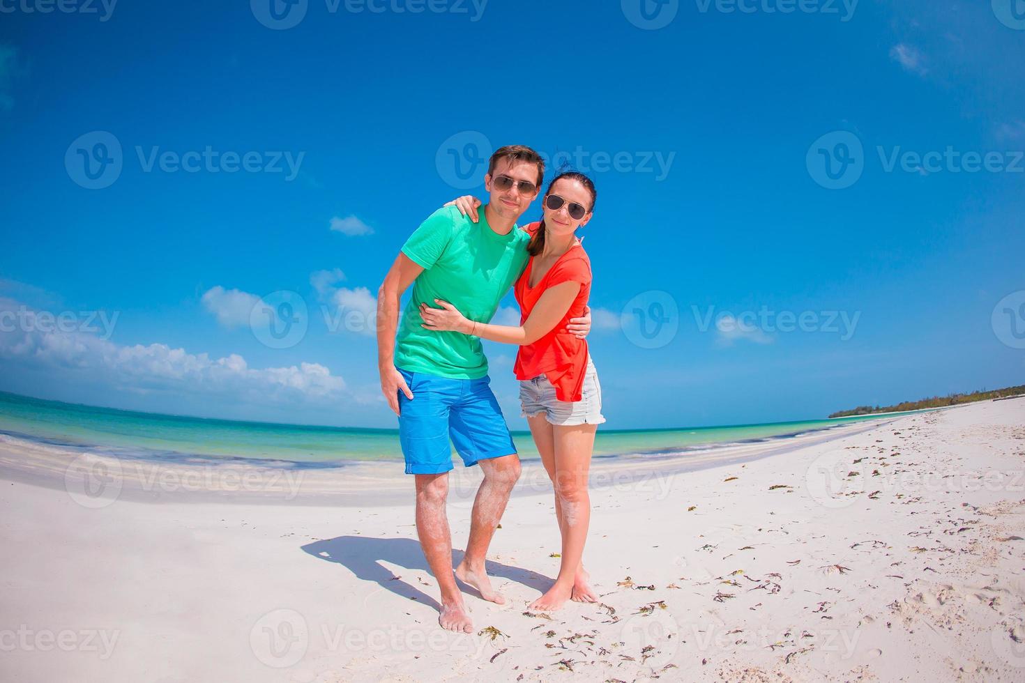 Young couple on white beach during summer vacation. photo
