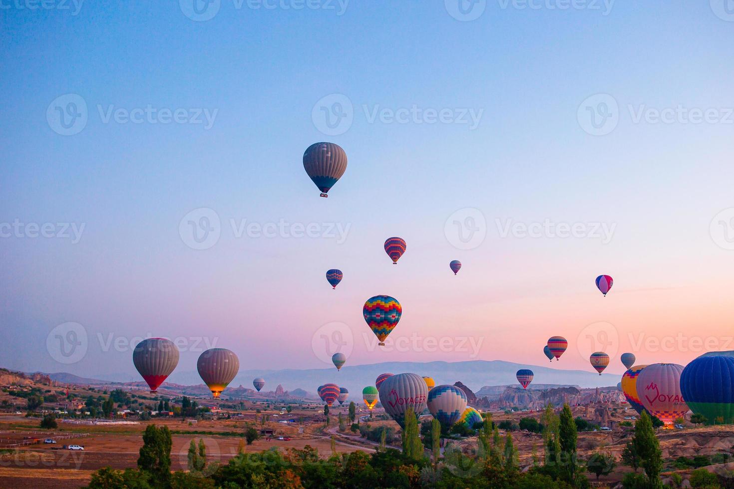 Hot air balloon flying over rocky landscapes in Cappadocia with beautiful sky on background photo