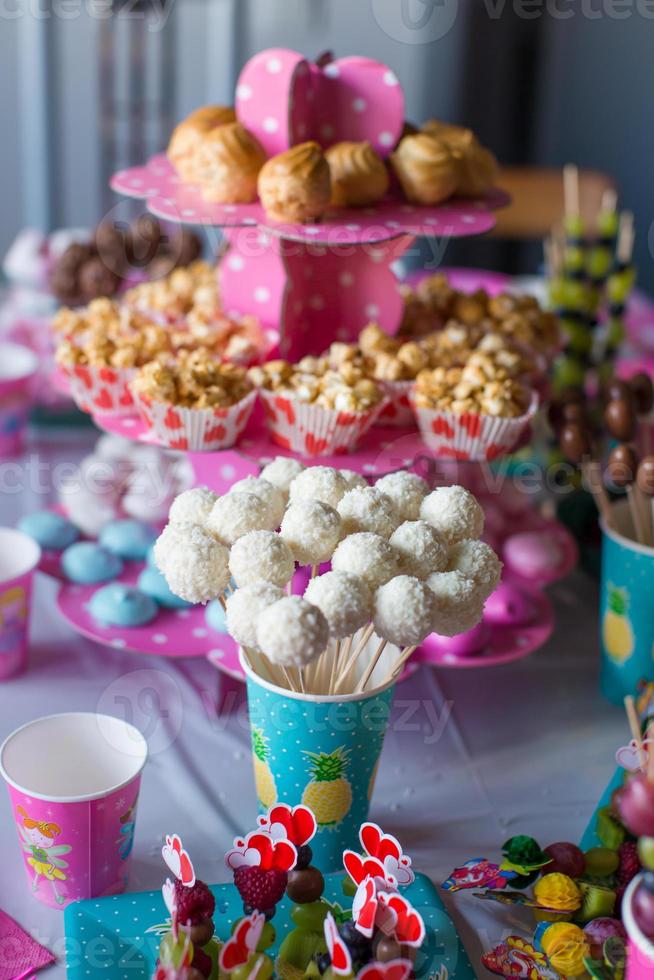 Cakepops de chocolate en la mesa de postres navideños en la fiesta de cumpleaños del niño foto