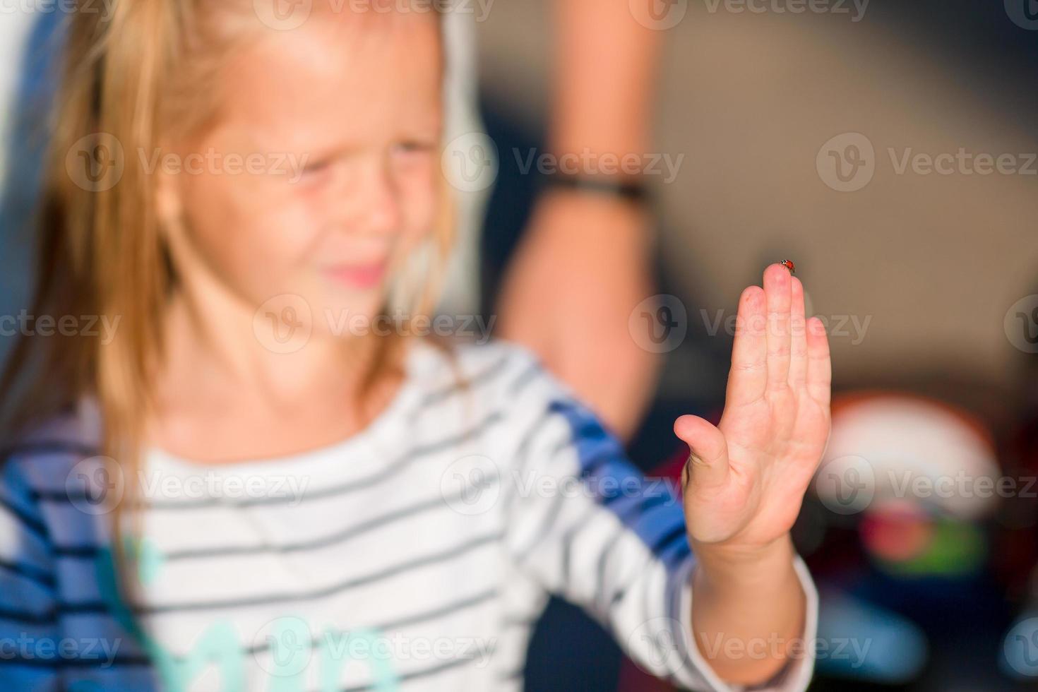 mariquita en la mano de una niña. Hora de verano. foto