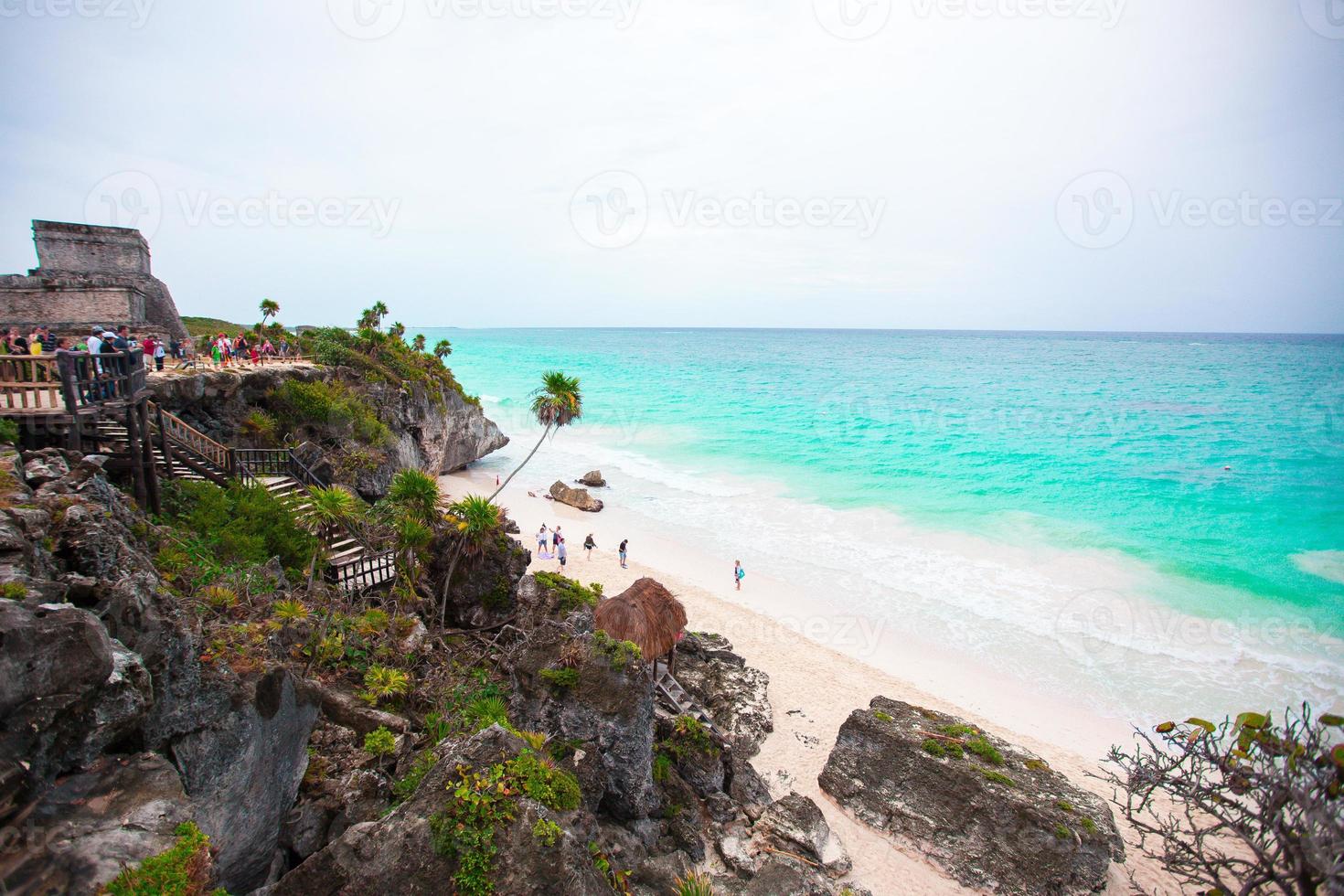 Stunning cliff side views of Tulum ruins by the Caribbean Sea in Mexico on sunny day. Magnificent views of Caribbean Sea of turquoise and blue water photo