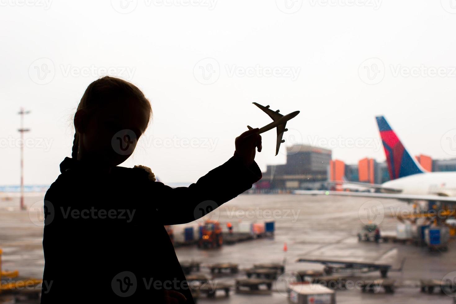 silueta de un pequeño modelo de avión en el aeropuerto en manos de los niños foto