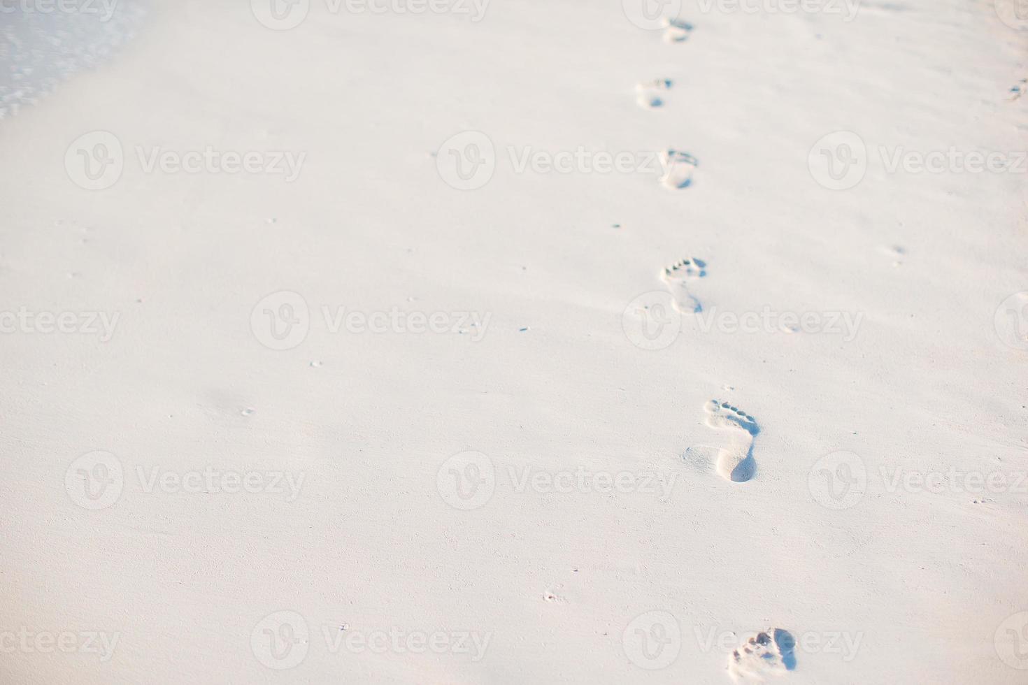 Footprints in the sand at sunset. Footsteps on the shore. photo