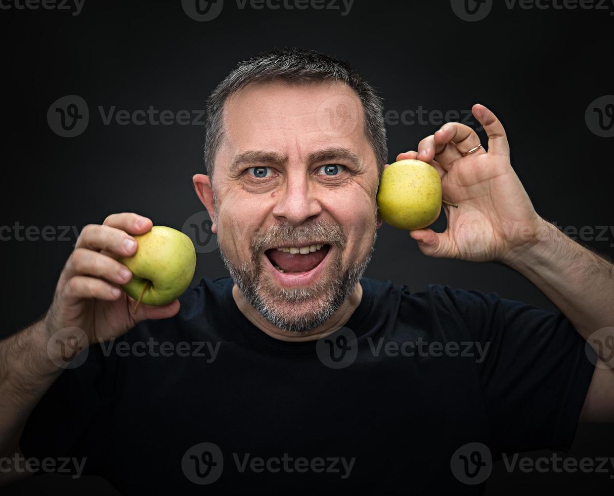 hombre de mediana edad con manzanas verdes foto