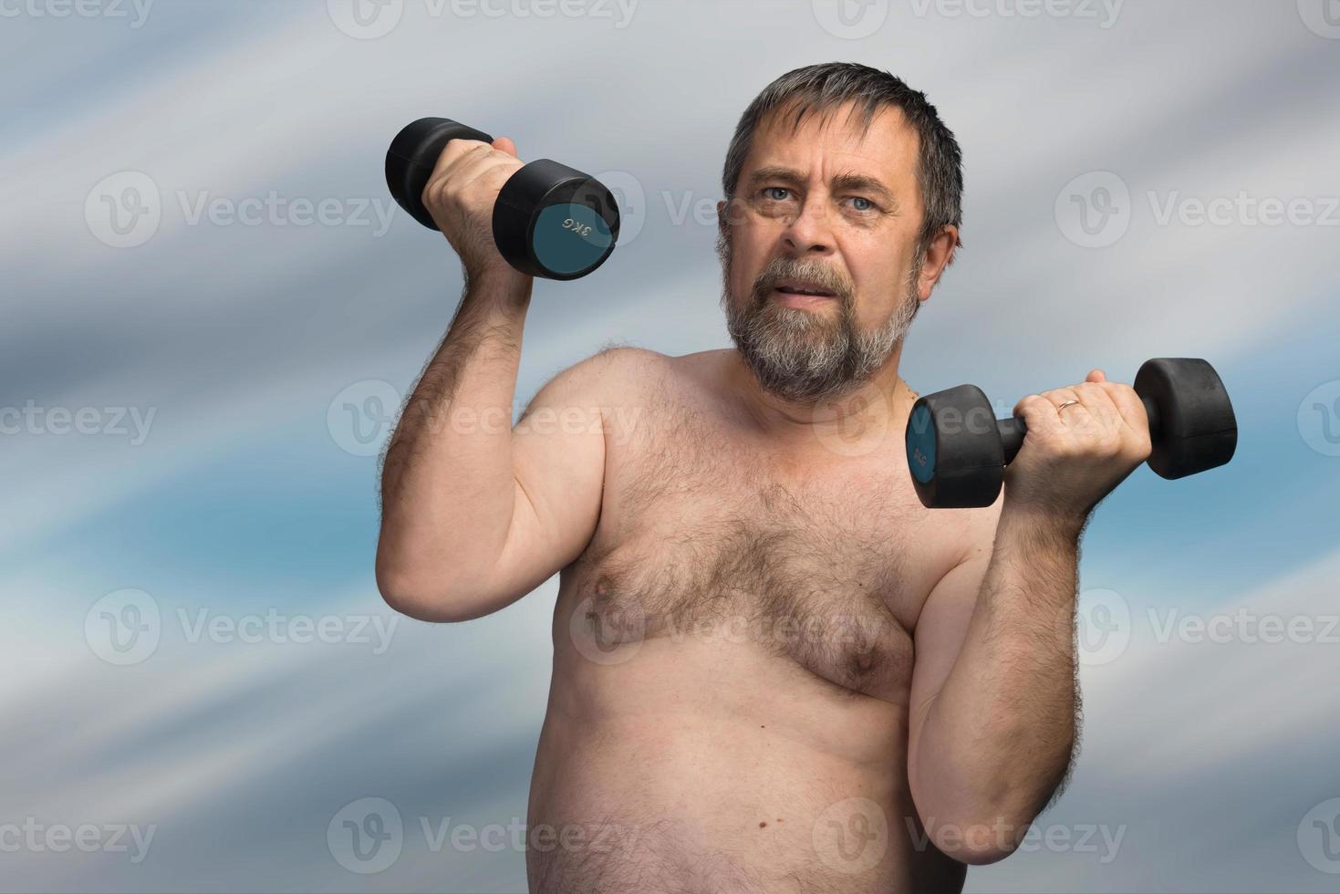 elderly fat man exercising with dumbbells photo