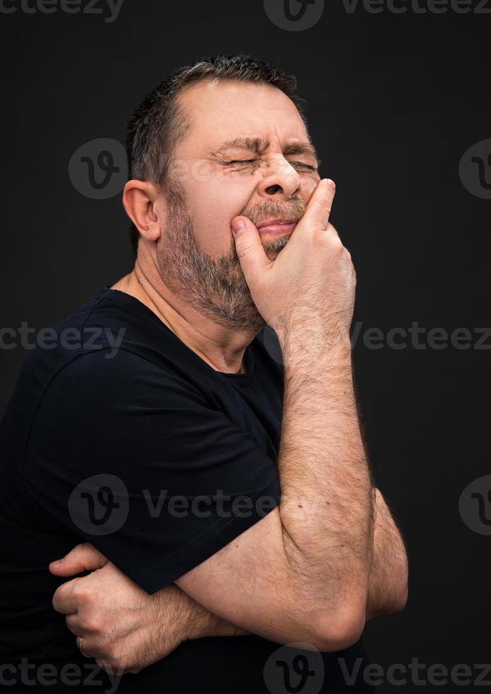 Headache. Man with face closed by hand photo