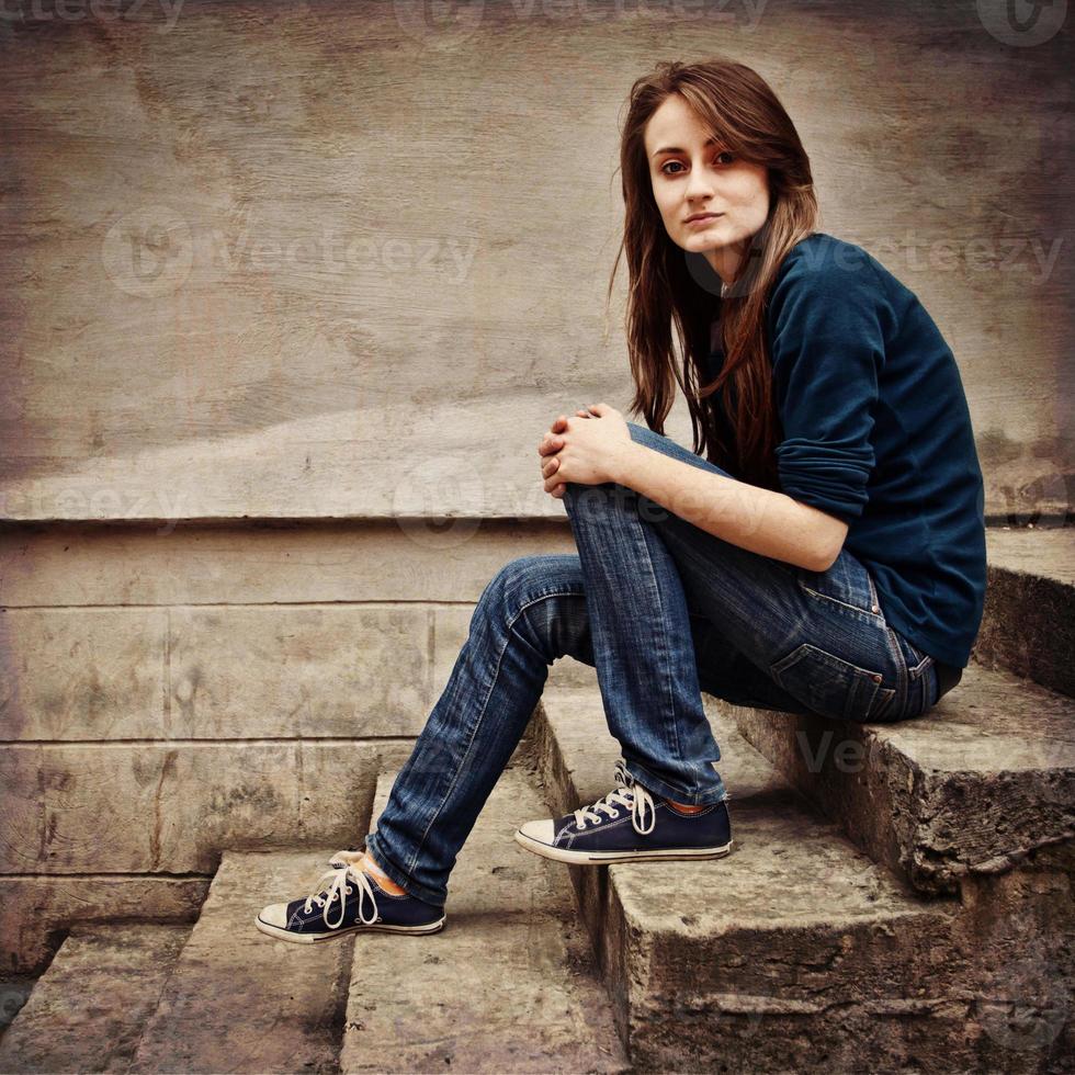 Teen girl sitting on a stone staircase photo