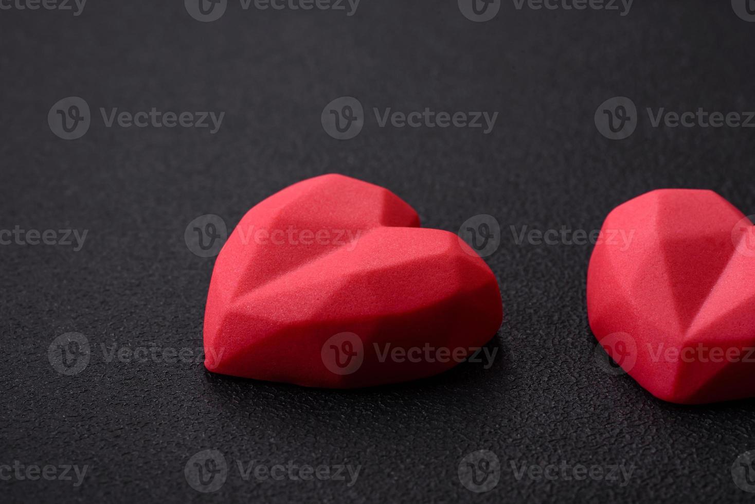 Delicious sweet heart shaped chocolate candies on a dark concrete background photo