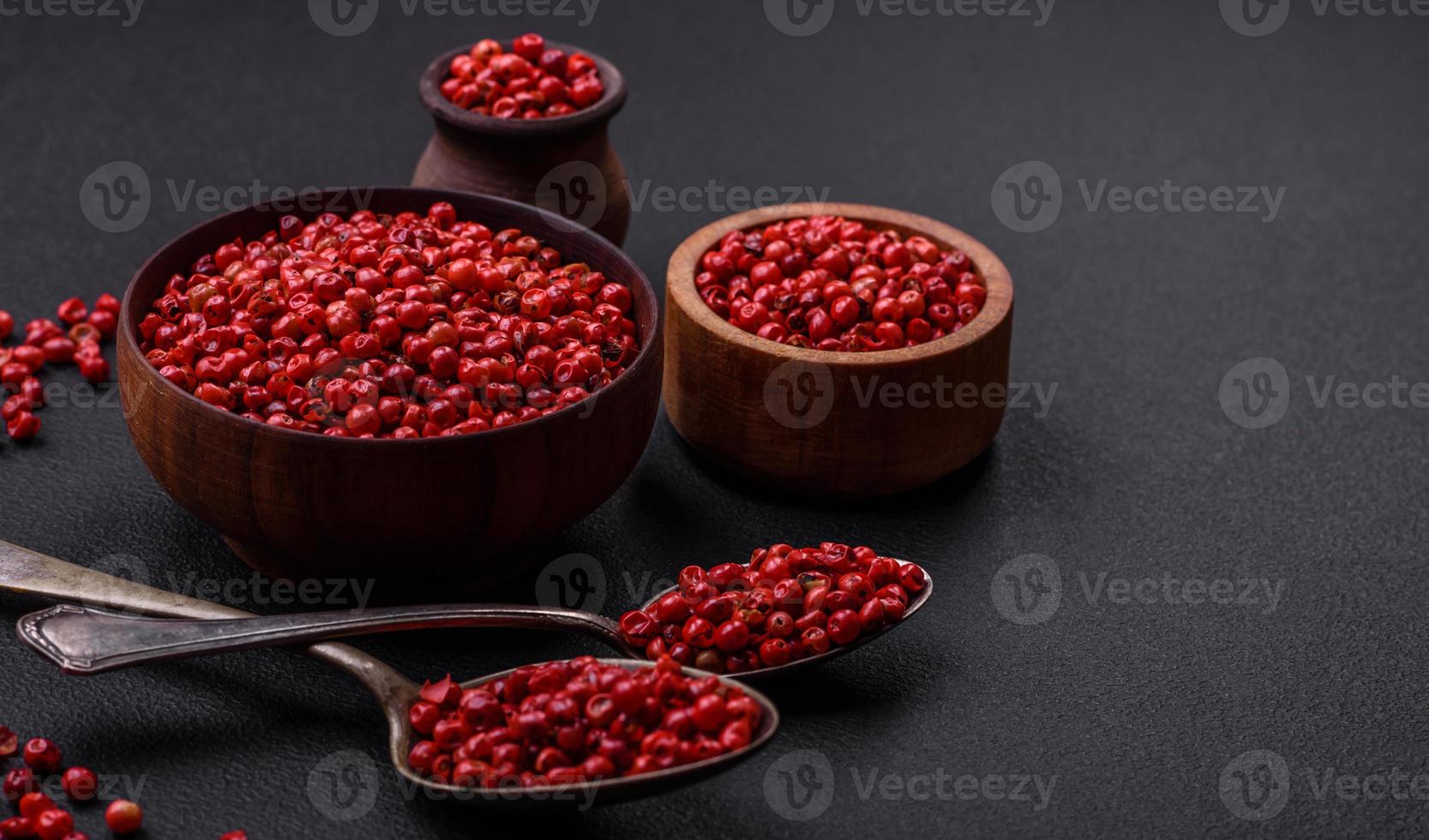 Spice, allspice peas of red or pink color in a wooden bowl photo