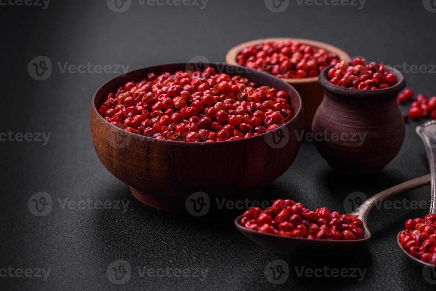 Spice, allspice peas of red or pink color in a wooden bowl photo