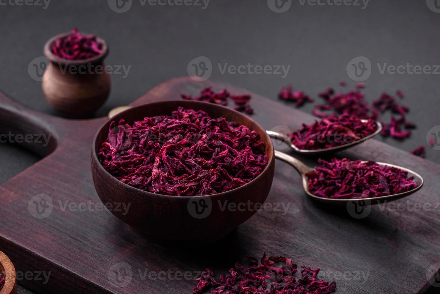 Dried beets in small slices in a wooden bowl on a black concrete background photo