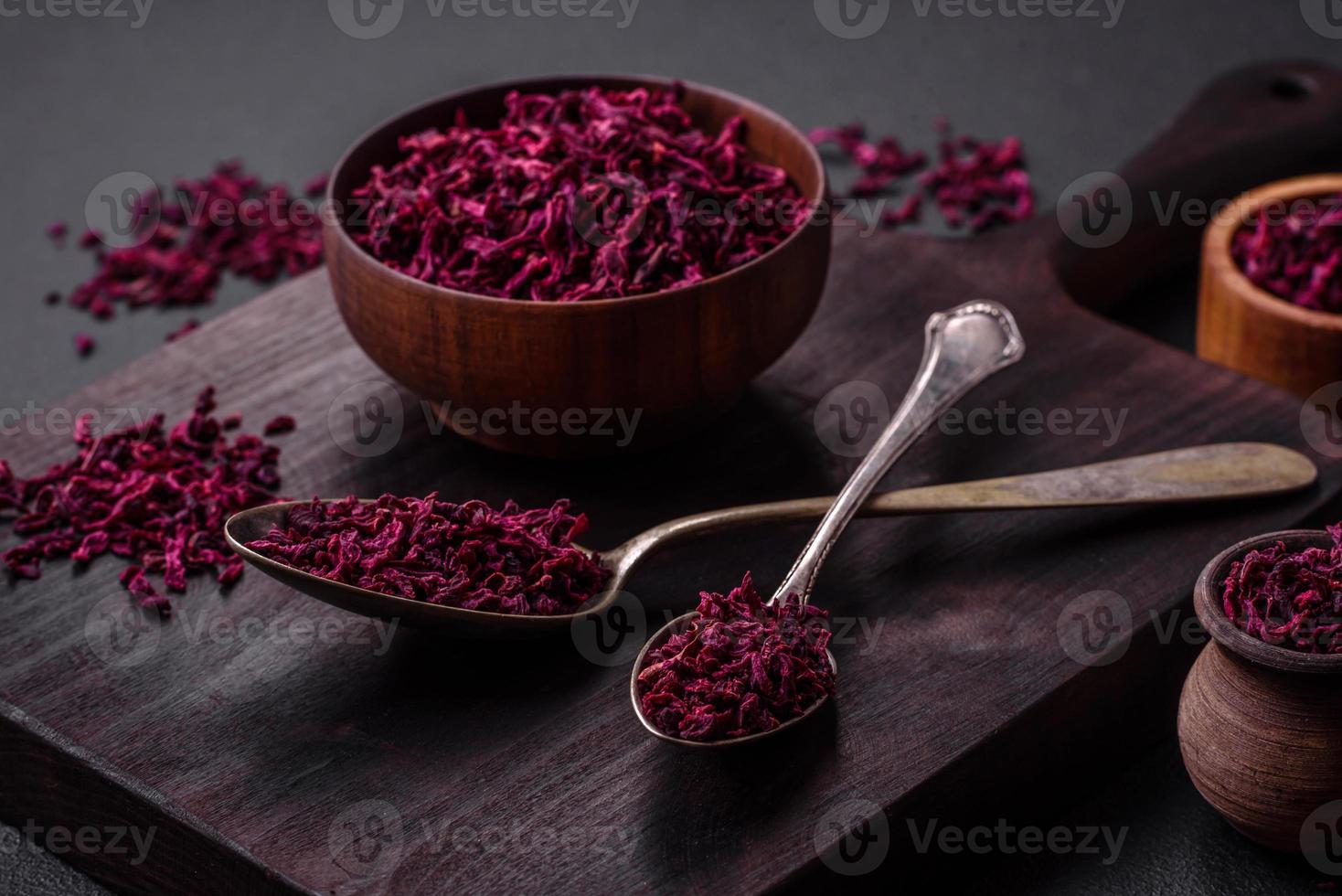 Dried beets in small slices in a wooden bowl on a black concrete background photo