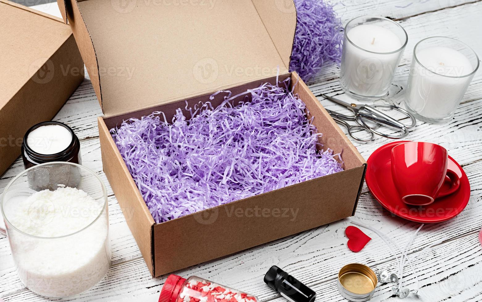 Seasonal opened gift box for valentine day with candle, red cup and heart shape sweets photo