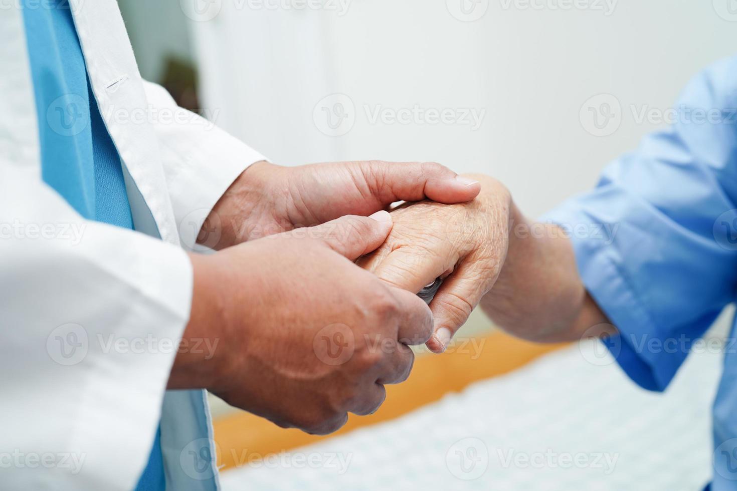 Doctor holding hands Asian elderly woman patient, help and care in hospital. photo