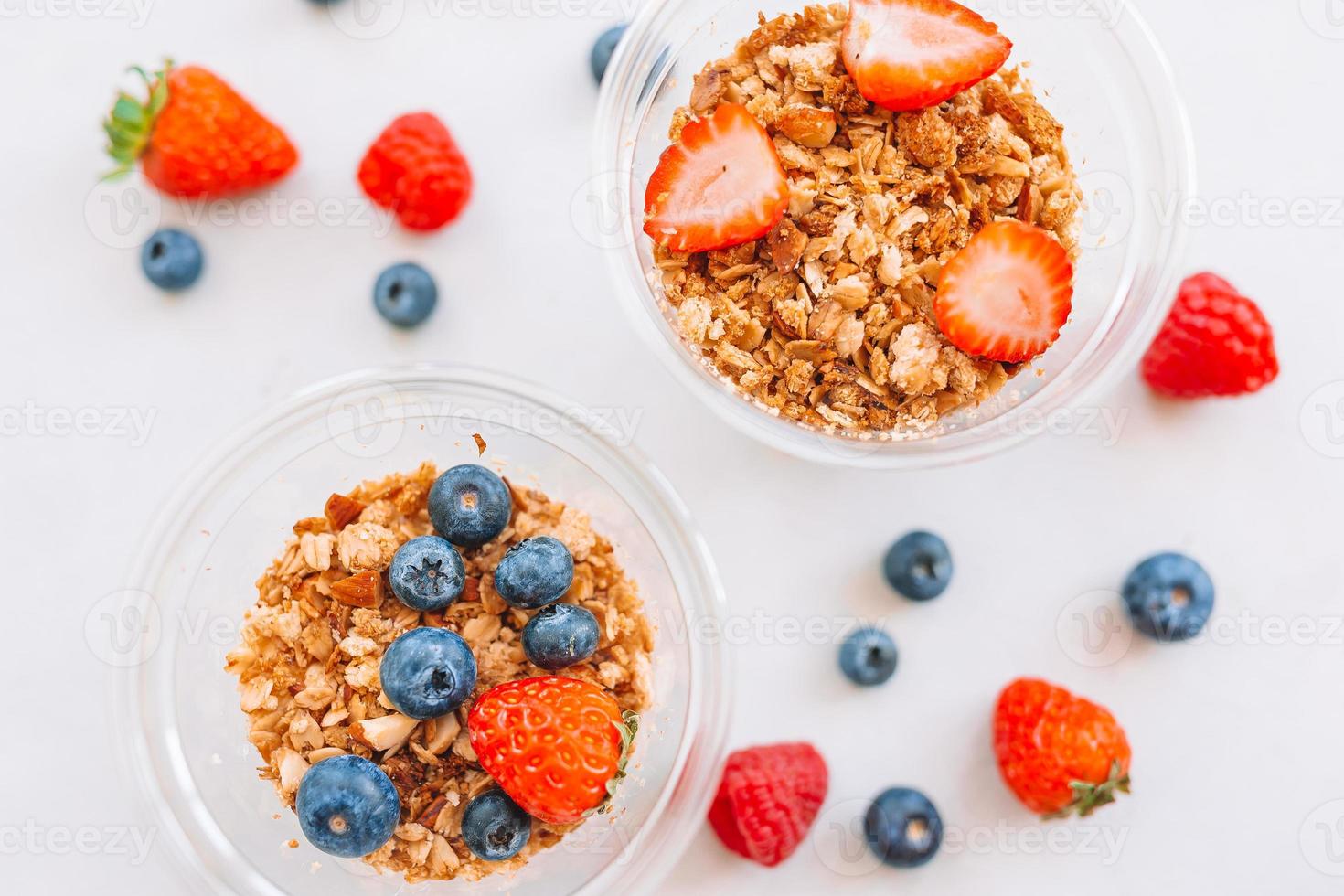 Oatmeal porridge in bowl topped with fresh blueberries, cranberries and homemade crunchy granola photo