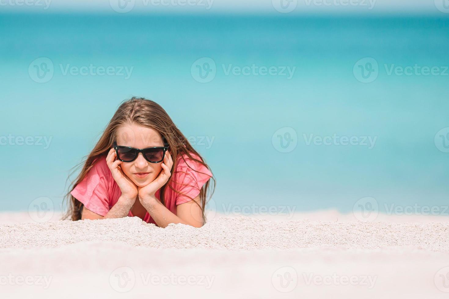 Adorable active little girl at beach during summer vacation photo