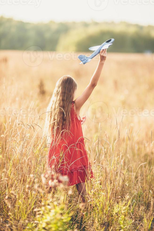 niña corriendo rápido y sosteniendo un avión de juguete foto