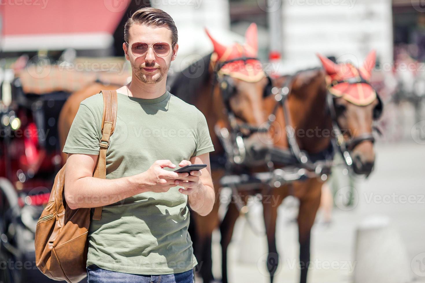 Man tourist with a city map and backpack in Europe street. Caucasian boy looking with map of European city. photo