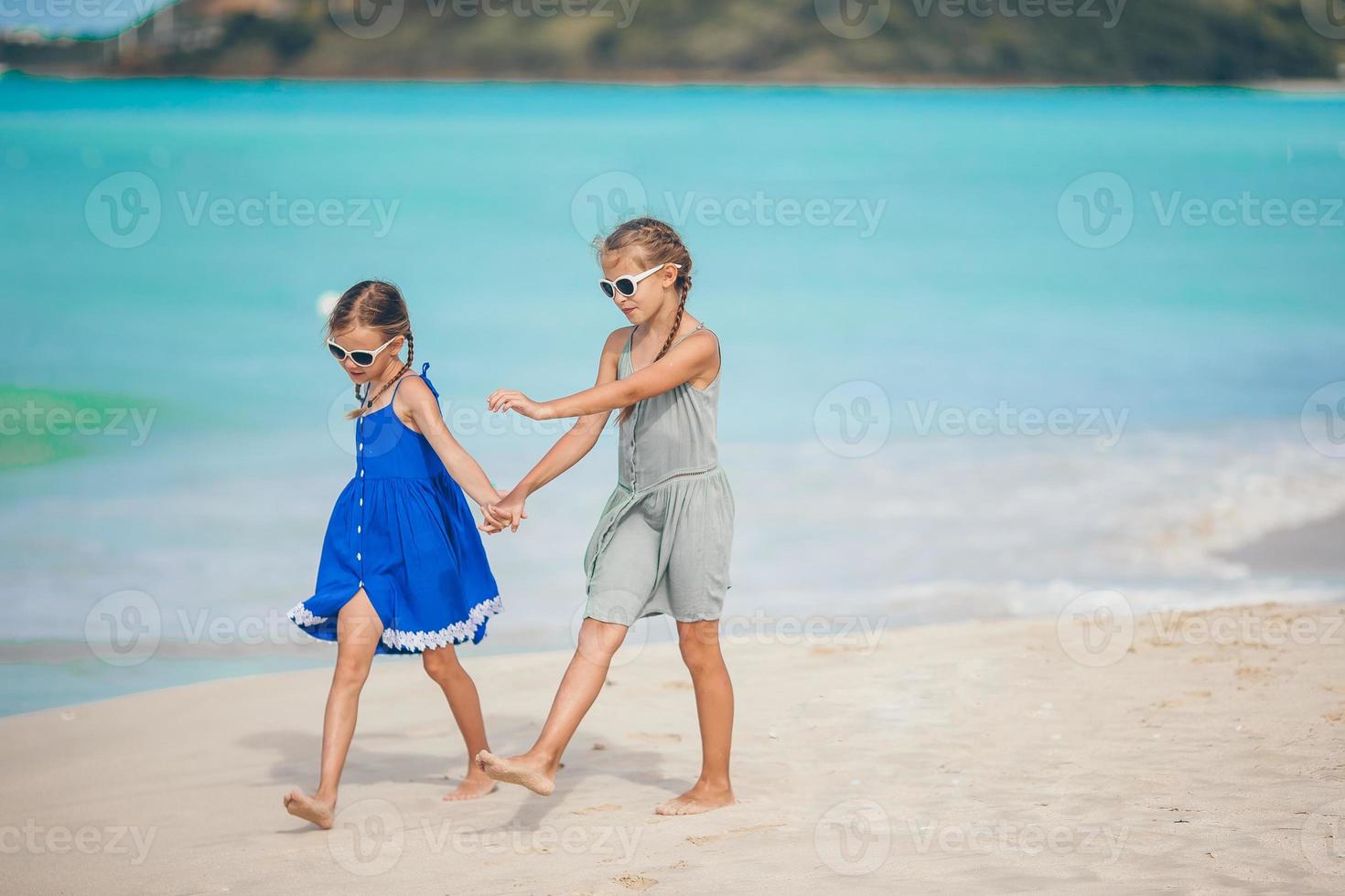 Little happy kids have a lot of fun at tropical beach playing together photo