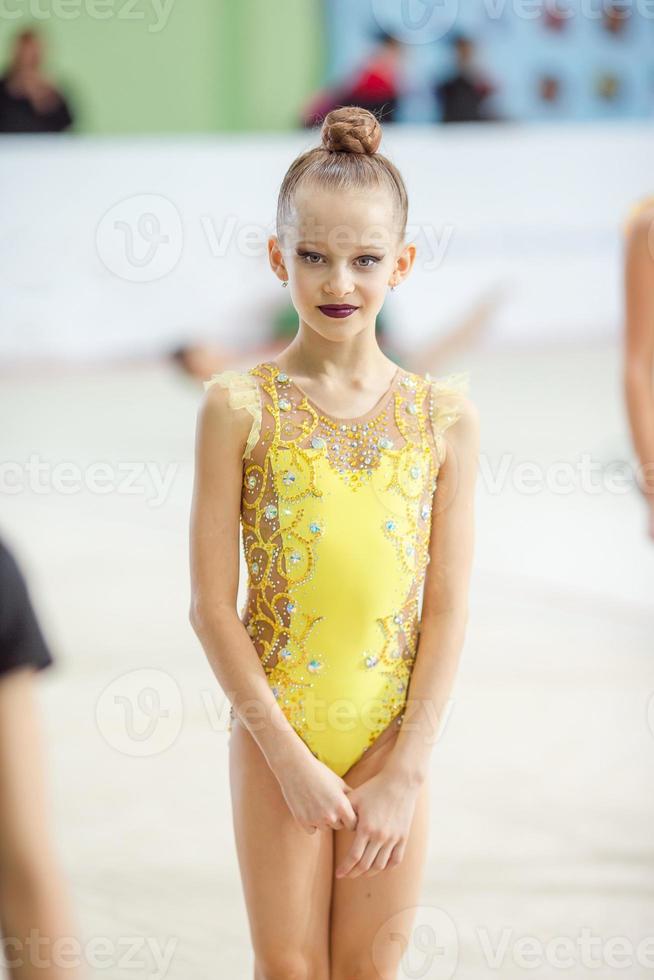 hermosa niña gimnasta activa con su actuación en la alfombra foto