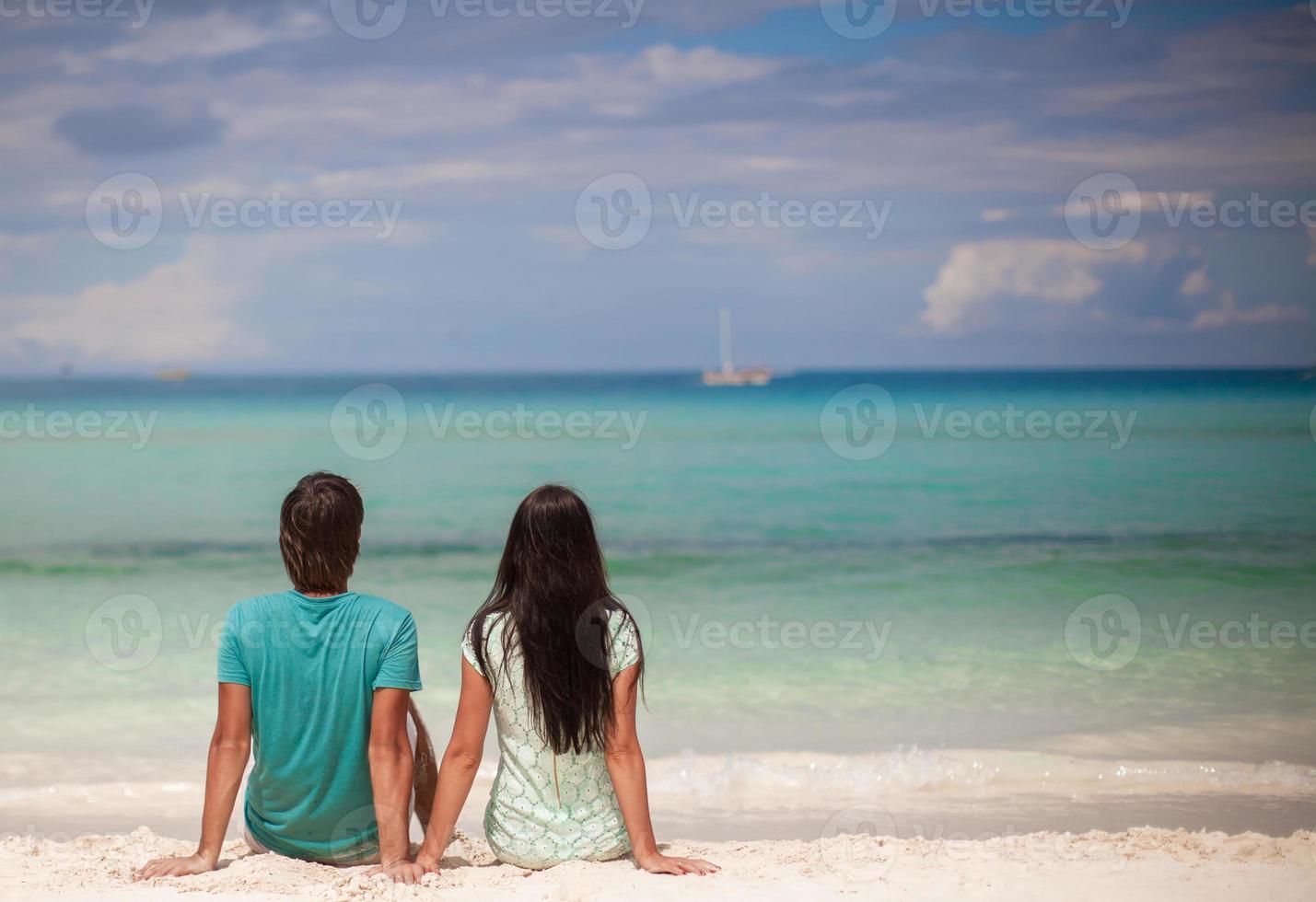 Young couple enjoying each other on sandy white beach photo