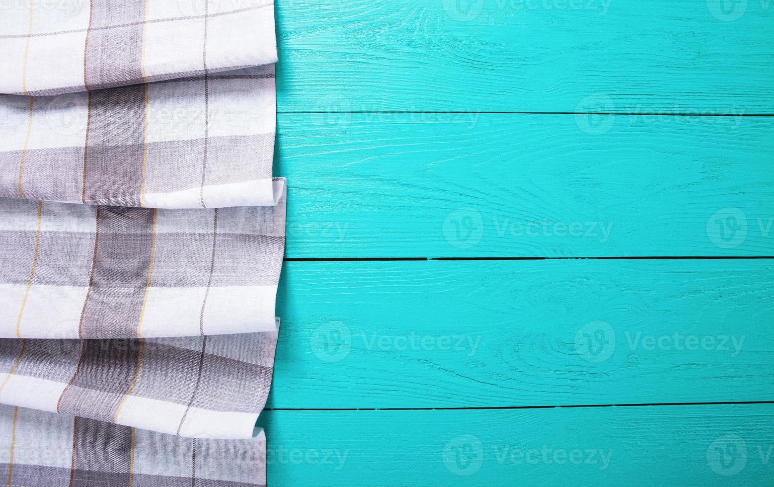 Grey plaid tablecloth on blue rustic wooden kitchen workspace, top view and copy space. Mock up and wood background. photo