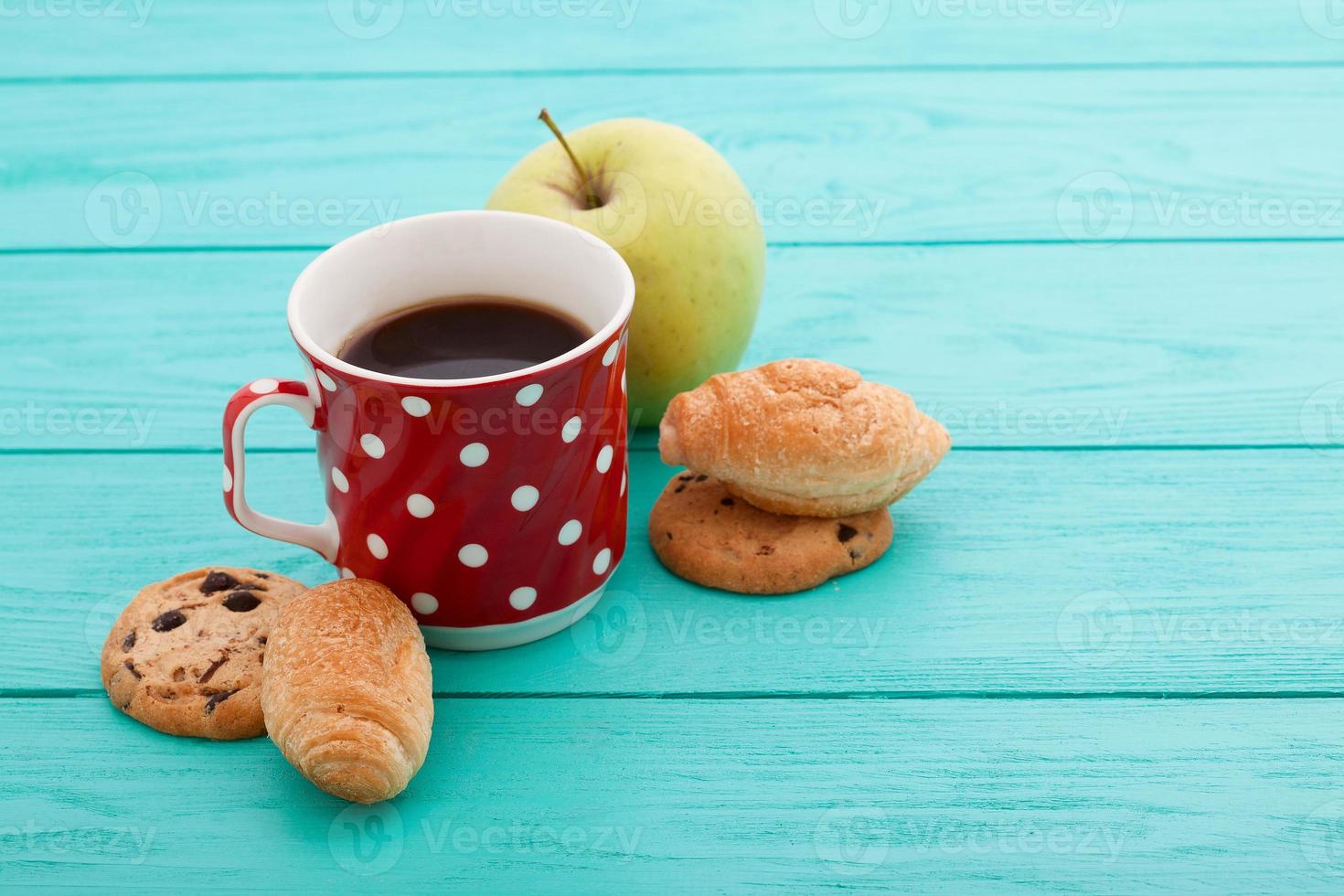 Cup of coffee with croissants and cookies and red roses on blue wooden background. Copy space. Mock up. Top view. Valentine mother day. photo