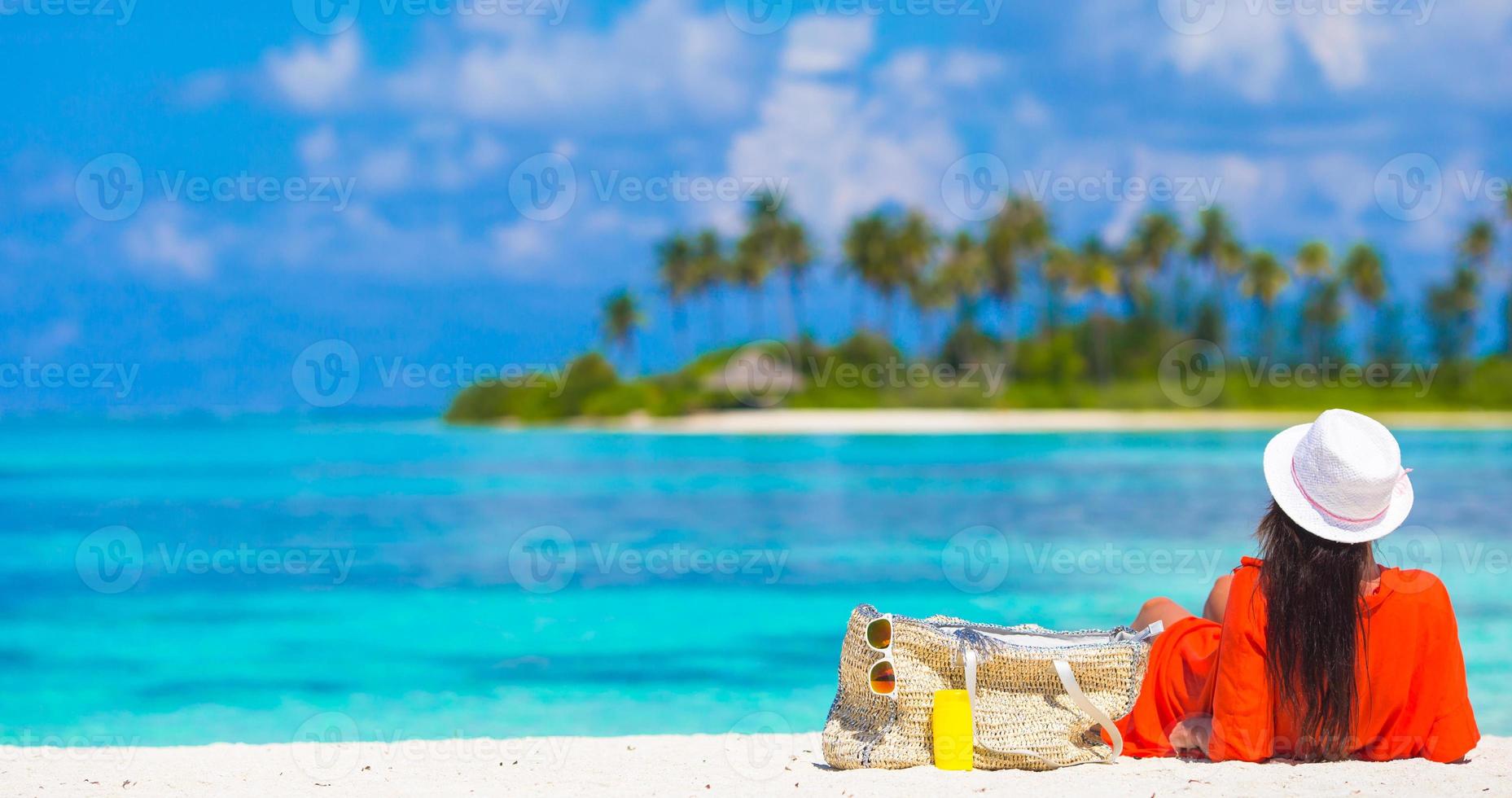 Beautiful young woman relaxing at white tropical beach photo