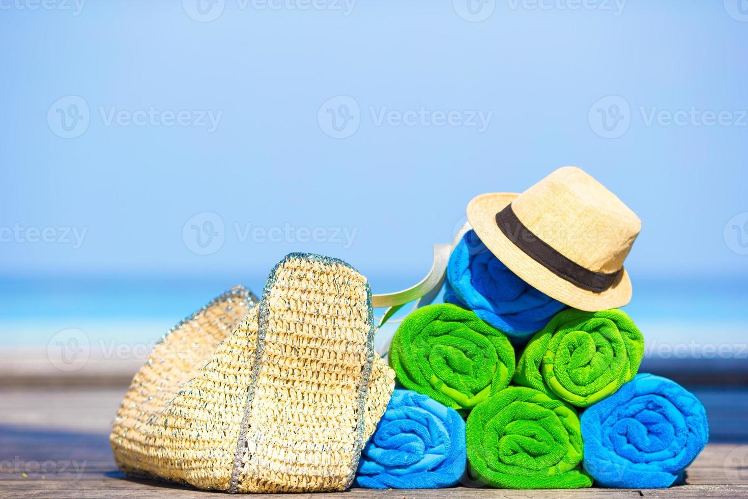 Beach and summer vacation accessories concept - close-up of colorful towels, hat, bag and sunblock photo