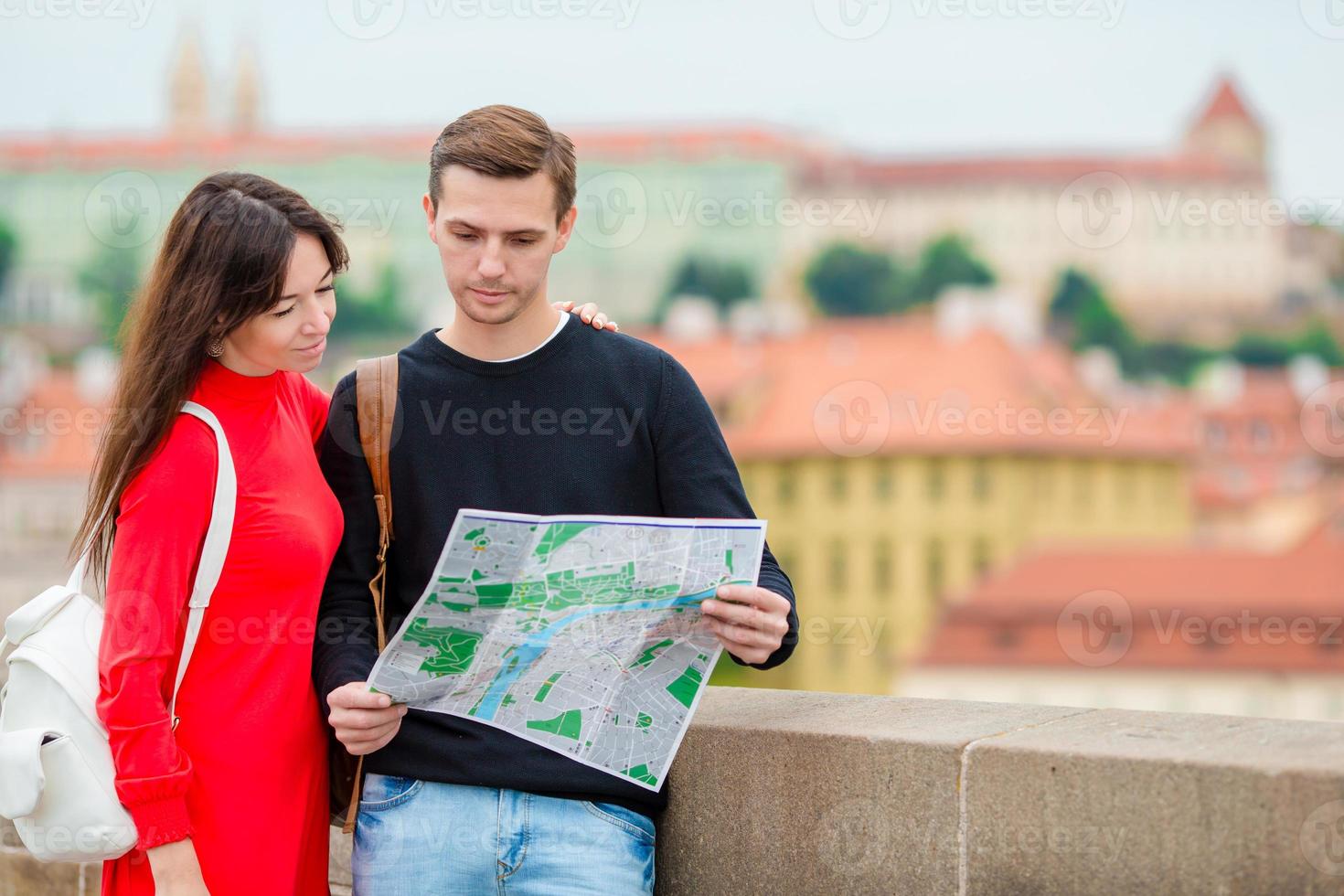 Romantic couple walking together in Europe. Happy lovers enjoying cityscape with famous landmarks. Stylish urban young man and woman with backpacks on travel in Prague photo