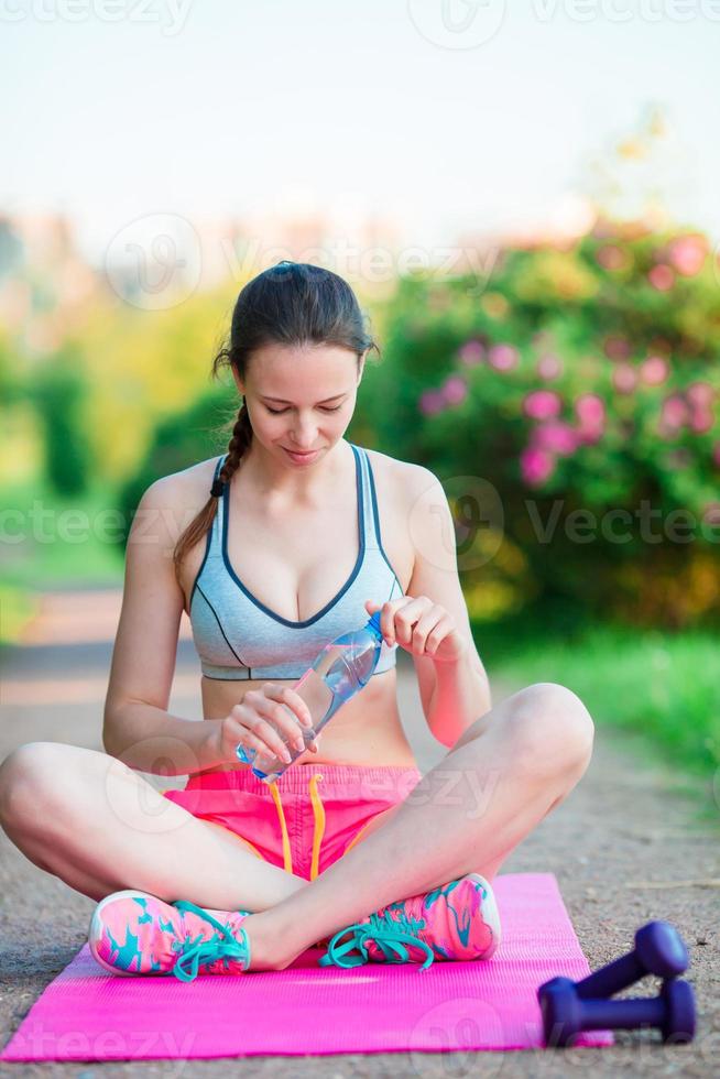 fitness mujer joven meditando en el parque. modelo de fitness femenino entrenando afuera en el parque. estilo de vida de fitness de bienestar saludable. foto