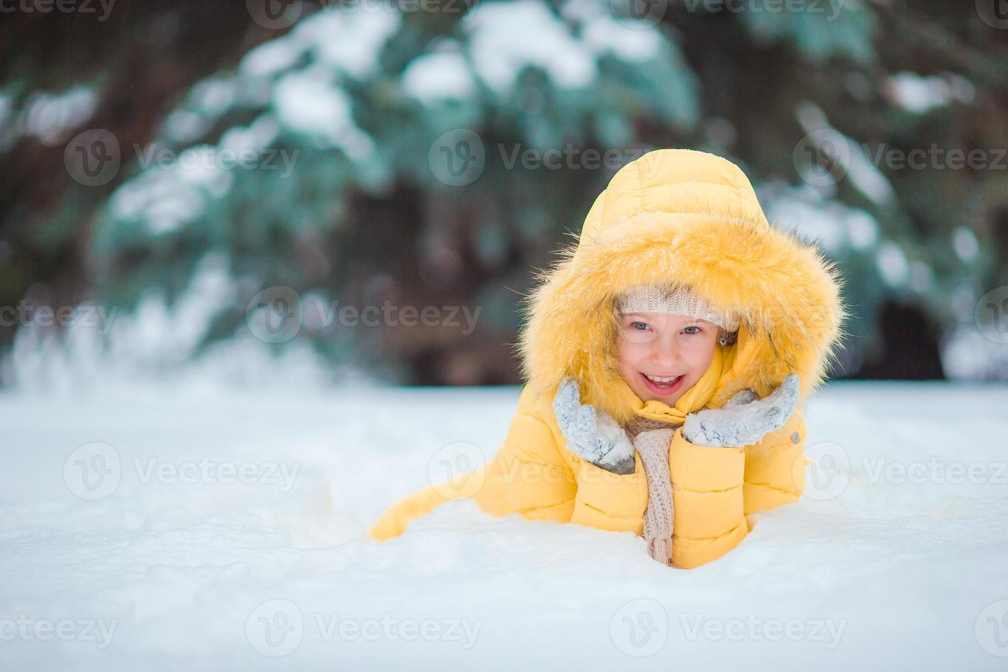 Portrait of little adorable girl with beautiful green eyes in snow sunny winter day photo
