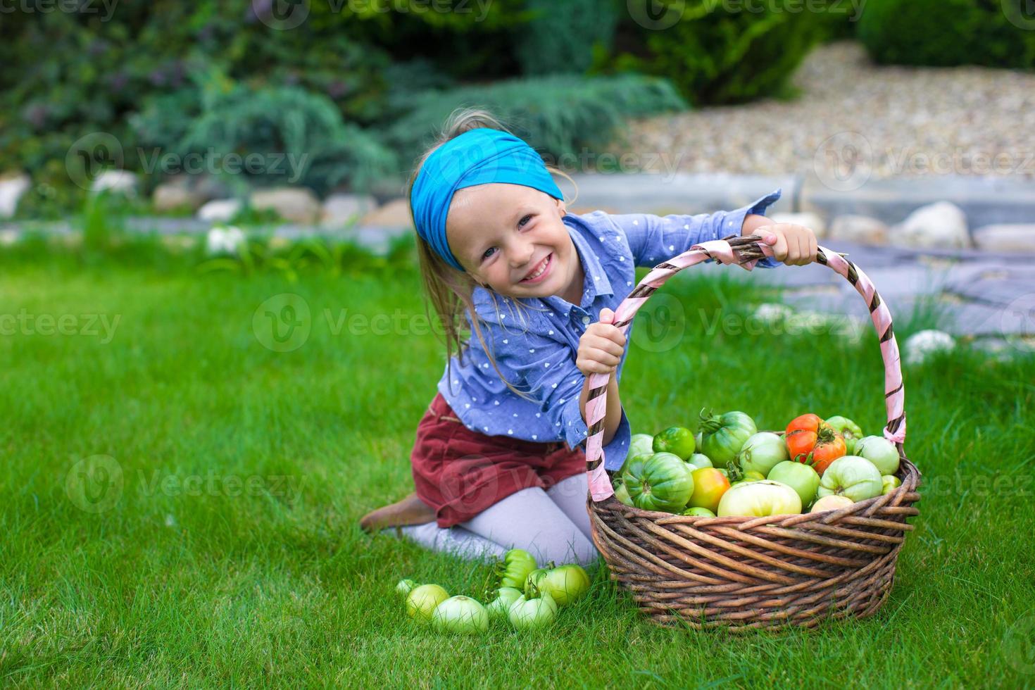 Little girl with baskets full of tomatoes photo