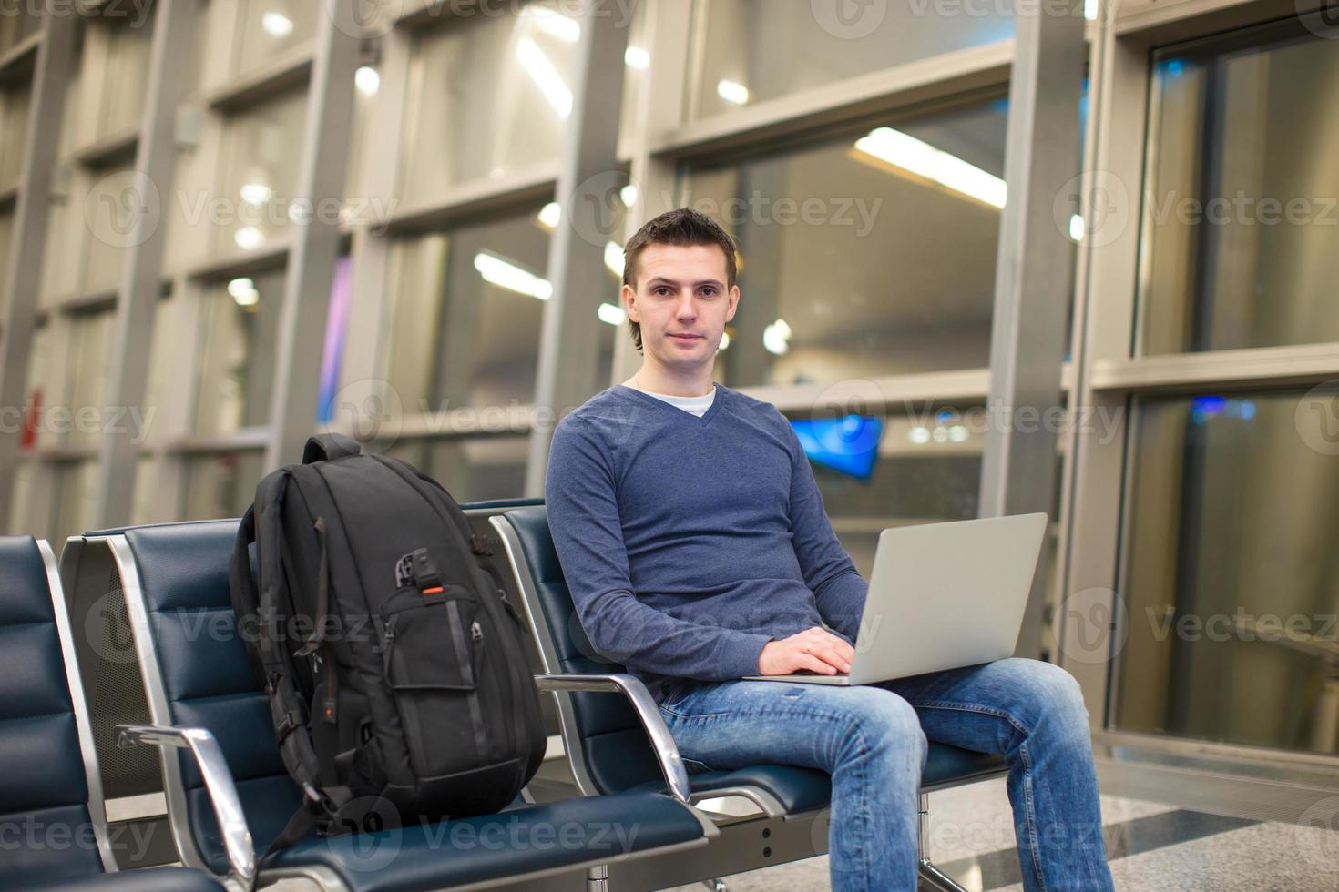 joven con laptop y mochila en el aeropuerto foto