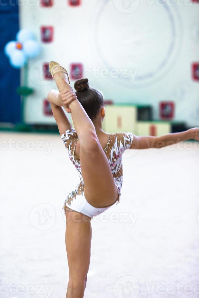 pequeña gimnasta entrenando en la alfombra y lista para las competencias foto