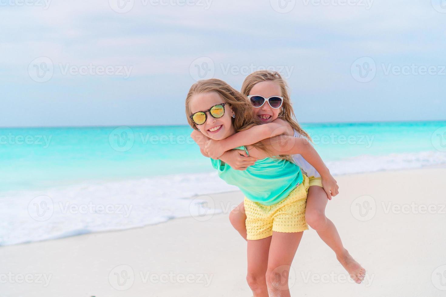 Adorable little kids play together on the beach photo