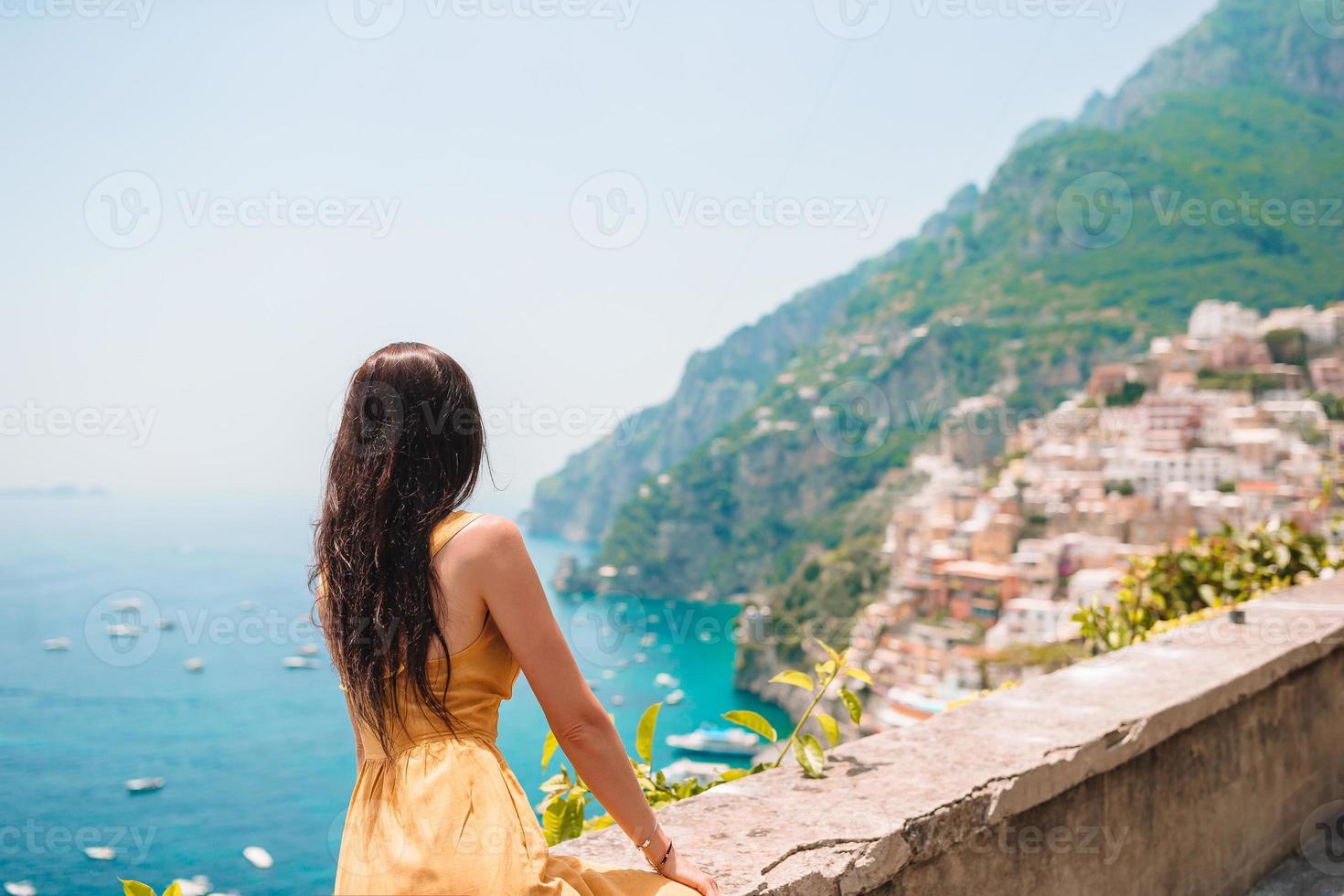 Summer holiday in Italy. Young woman in Positano village on the background, Amalfi Coast, Italy photo