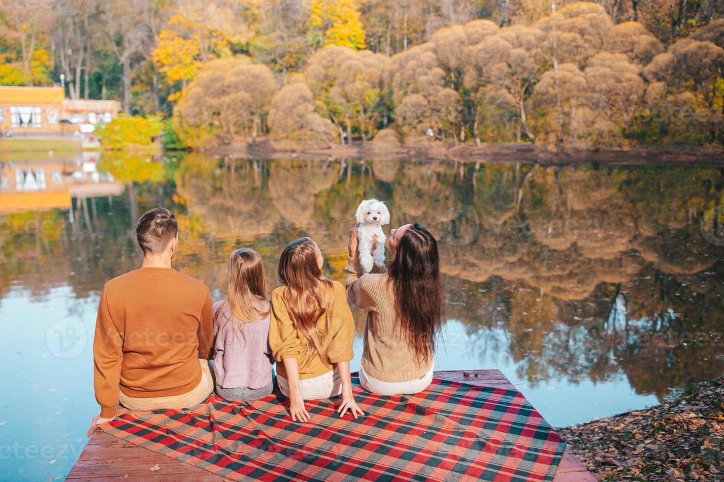 Beautiful family at autumn warm day near lake photo