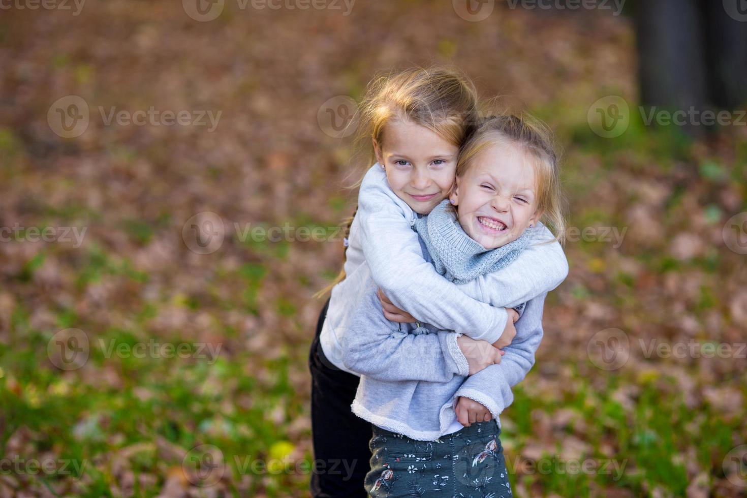 niñas adorables en un día cálido en el parque de otoño al aire libre foto