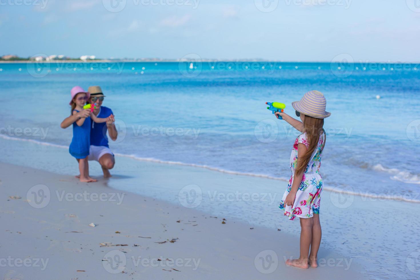 Little girl playing with family at the beach photo