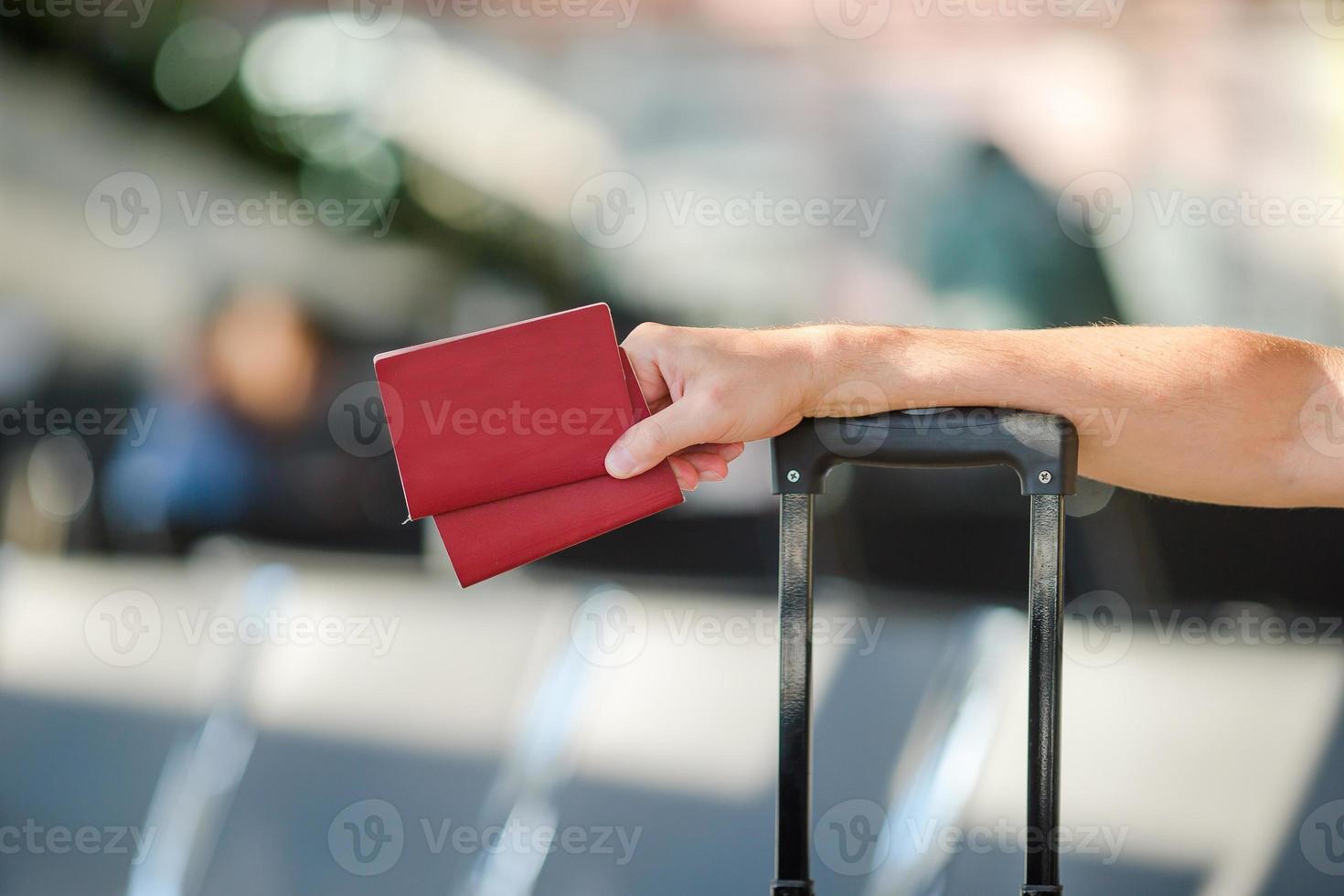 Closeup of man holding passports and boarding pass at airport photo